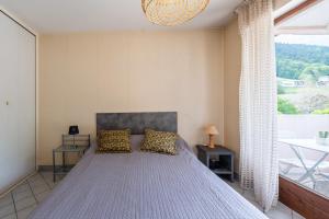 a bedroom with a bed and a large window at Résidence du parc in Thônes