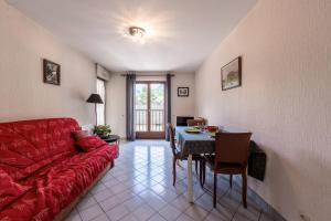 a living room with a red couch and a table at Résidence du parc in Thônes
