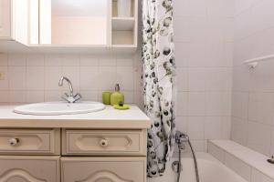 a bathroom with a sink and a shower curtain at Résidence du parc in Thônes +16 photos