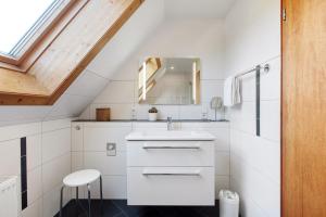 a white bathroom with a sink and a mirror at Haus Barbara in Bernau im Schwarzwald +40 photos