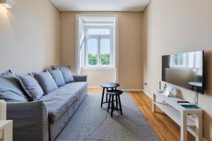 a living room with a couch and a tv at Setubal Prime, By Home Match in Setúbal