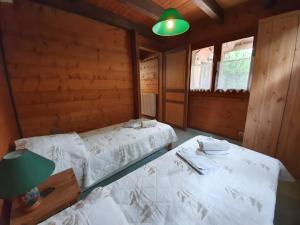 two beds in a room with wooden walls at Chalet Du Saix - Sauna in La Chapelle-dʼAbondance