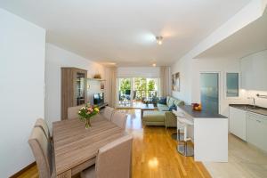 a kitchen and living room with a wooden table and a dining room at Rotonda Spaniahome in L'Alfàs del Pi