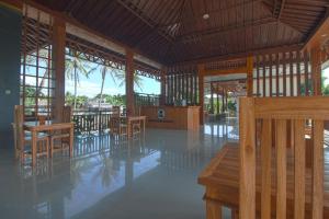 a restaurant with wooden tables and chairs and a podium at Pohon Purba Resort & Restaurant in Pulau Lebur