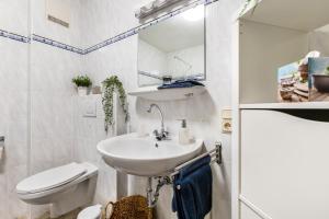 a white bathroom with a sink and a toilet at Ferienwohnung an der Kriemhildmühle in Xanten +27 photos