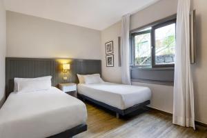 a hotel room with two beds and a window at HG Lomo Blanco in Puerto del Carmen +42 photos