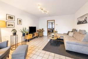 a living room with a couch and a tv at Ferienwohnung an der Kriemhildmühle in Xanten