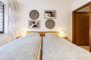 two beds in a bedroom with two lamps and pictures on the wall at Ferienwohnung an der Kriemhildmühle in Xanten