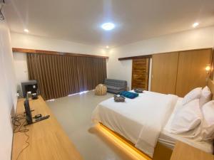 a bedroom with a bed and a desk with a phone at Yaya BCB in Gili Meno