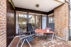 a patio with a table and chairs next to a brick wall at Ferienwohnung an der Kriemhildmühle in Xanten