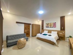 a hotel room with a bed and a couch at Yaya BCB in Gili Meno