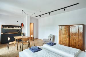 a room with two beds and a table and a kitchen at Alte Seifensiederei - Thay in Bad Tölz