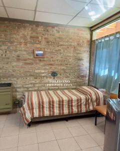 a room with a bed with a brick wall at Costa Azul 3 in Villa Pehuenia