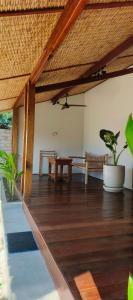 a living room with a wooden floor and a wooden table at Yaya BCB in Gili Meno