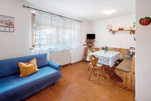 a living room with a blue couch and a table at Appartamenti Adriano Minotto in Falcade