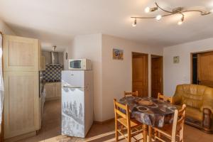 a kitchen and dining room with a table and a refrigerator at Les Sources Gîte La Remise in Chambonas
