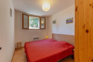 a bedroom with a red bed and a window at Les Sources Gîte La Remise in Chambonas +16 photos