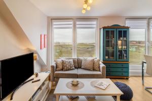 a living room with a couch and a tv at Ferienhaus Raschke in Norderney
