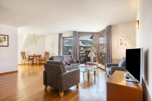 a living room with a couch and chairs and a tv at Appartmenthaus Felicitas in Willingen