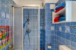 a bathroom with blue tiled walls and a shower at Ferienhaus Raschke in Norderney +9 photos