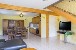 a living room with a tv and a kitchen at Gîte cerf in Rupt-sur-Moselle