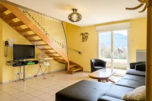a living room with a couch and a staircase at Gîte cerf in Rupt-sur-Moselle