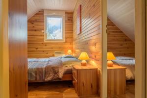 a bedroom with wooden walls and a bed with two lamps at Gîte cerf in Rupt-sur-Moselle