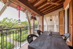 a wooden table and chairs on a balcony with a view at Residence La Piopa in Polpenazze del Garda