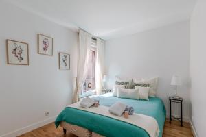 a bedroom with a large bed with towels on it at Appartement Cosy in Paris