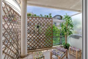 a balcony with a lattice screen and two chairs at Appartement Cosy in Paris