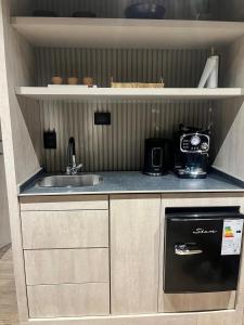 a small kitchen with a sink and a stove at Lun Lodges in Ciudad Lujan de Cuyo