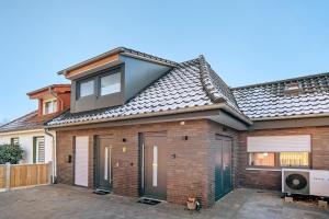 a large brick house with a roof at Neubau Ferienwohnung mit Balkon in Gronau