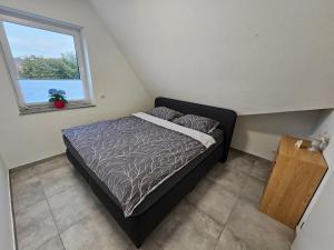 a small bedroom with a bed and a window at Neubau Ferienwohnung mit Balkon in Gronau