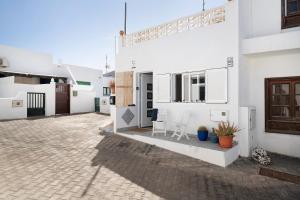 a courtyard of a house with two chairs and a table at Casa Marion in El Golfo
