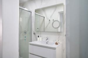 a white bathroom with a sink and a mirror at Casa Marion in El Golfo