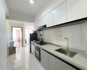 a white kitchen with a sink and a stove at Shangri-la residence Westlands-Remote working & gym in Nairobi