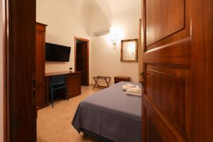 a hotel room with a bed and a television at Hotel Villa Cute - HVC in Lipari