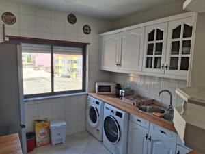a kitchen with a sink and a washing machine at Lisbon south side apartments in Barreiro +5 photos