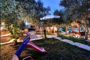 a childs slide in a yard with an umbrella at Robinson House with Pool & Seaview in Ždrelac