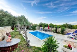 a backyard with a swimming pool and a table and chairs at Robinson House with Pool & Seaview in Ždrelac
