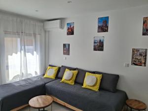 a living room with a couch with yellow pillows at Lisbon south side apartments in Barreiro