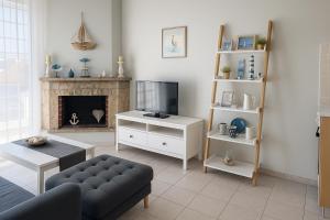 ein Wohnzimmer mit Sofa und Fernseher in der Unterkunft Lucky's studio in Ofrynio
