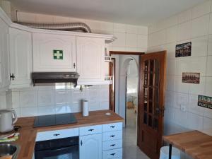 a kitchen with white cabinets and a sink at Lisbon south side apartments in Barreiro