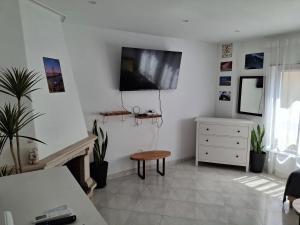 a living room with a tv on a white wall at Lisbon south side apartments in Barreiro