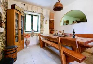a dining room with a wooden table and a bench at Robinson House with Pool & Seaview in Ždrelac +18 photos