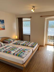 two beds in a room with two windows at Ferienhof Rohrbachhof in Schiltach