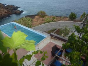 a swimming pool with a view of the ocean at Villa Halcyon Caboverde in Cidade Velha