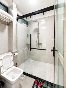 a bathroom with a toilet and a glass shower at Shangri-la residence Westlands-Remote working & gym in Nairobi
