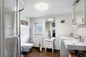 a white bathroom with a toilet and a sink at Wünsch Dir was in Großweitzschen +20 photos