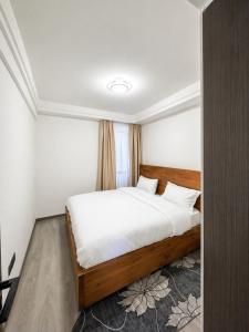 a bedroom with a large bed with white sheets at Shangri-la residence Westlands-Remote working & gym in Nairobi +2 photos